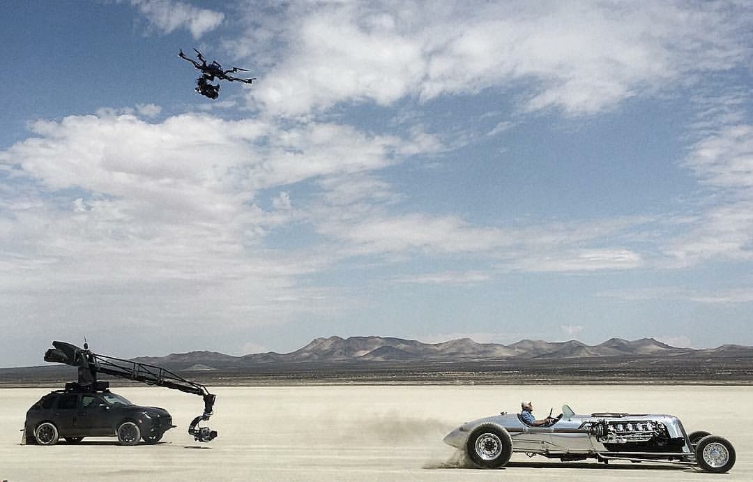 Full-scale production — camera car, drone and race car on location in the Mojave Desert