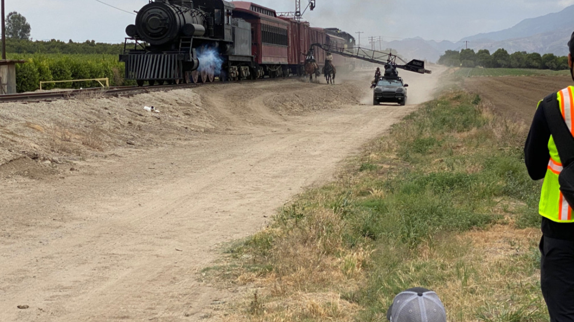 Train robbery production — moving steam train, horses and camera vehicle